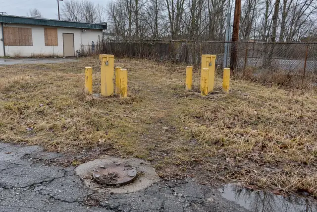 Stick-up and flush-mount groundwater monitoring wells behind a former gas station